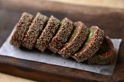 Close-up image of Anjeer Pista Mithai, a traditional Indian sweet made with layers of dried figs (Anjeer) and crunchy pistachios (Pista), shaped into squares or rounds. A nutritious and delicious dessert perfect for special occasions and gifting.