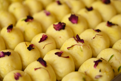 Close-up image of Kesar Peda, a traditional Indian sweet made with sweetened khoya, infused with Kesar (saffron) and Elaichi (cardamom), and shaped into small, round pieces. Garnished with saffron strands, this delicacy is perfect for festive occasions and gifting.